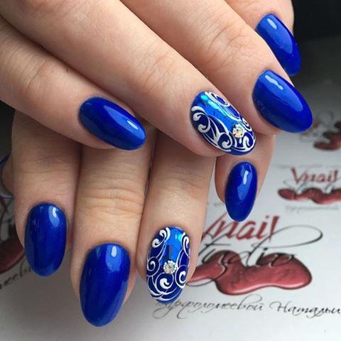 Синій манікюр з абстрактним ручним розписом та сріблястими стразами