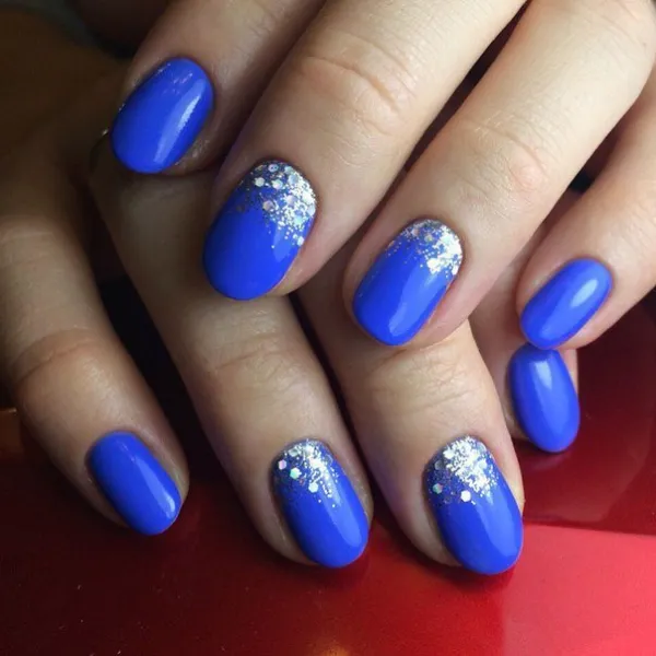 Синій блискучий манікюр: овальні нігті зі срібним сяйвом