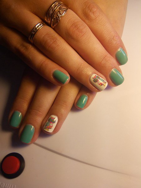 Блискучий зелений манікюр на овальних нігтях з білими акцентами