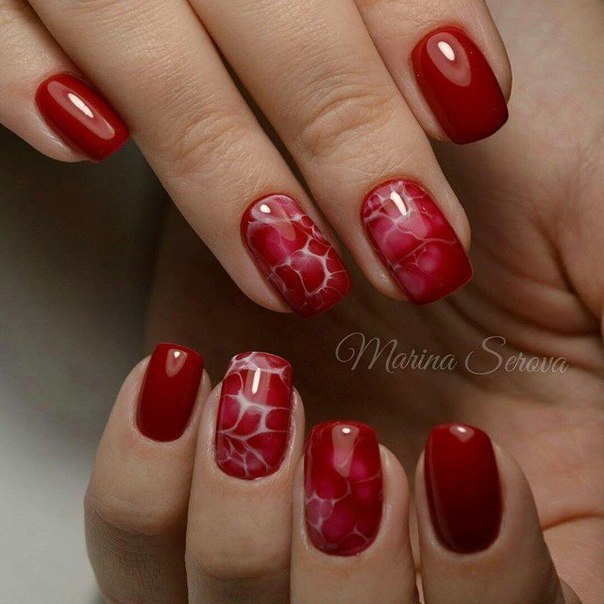 Абстрактний червоний манікюр з білим мармуром на овальних нігтях