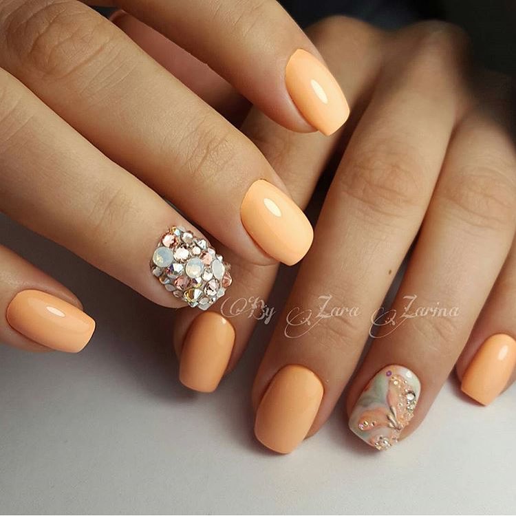 Помаранчевий манікюр з 3D сріблястими квітами та стразами