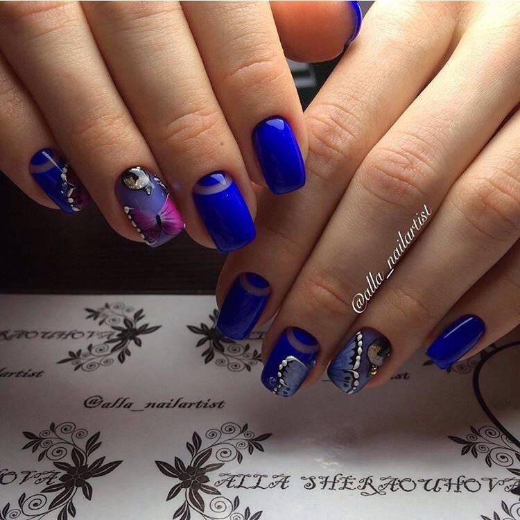 Синій манікюр з фіолетовими квітами та сріблястими стразами