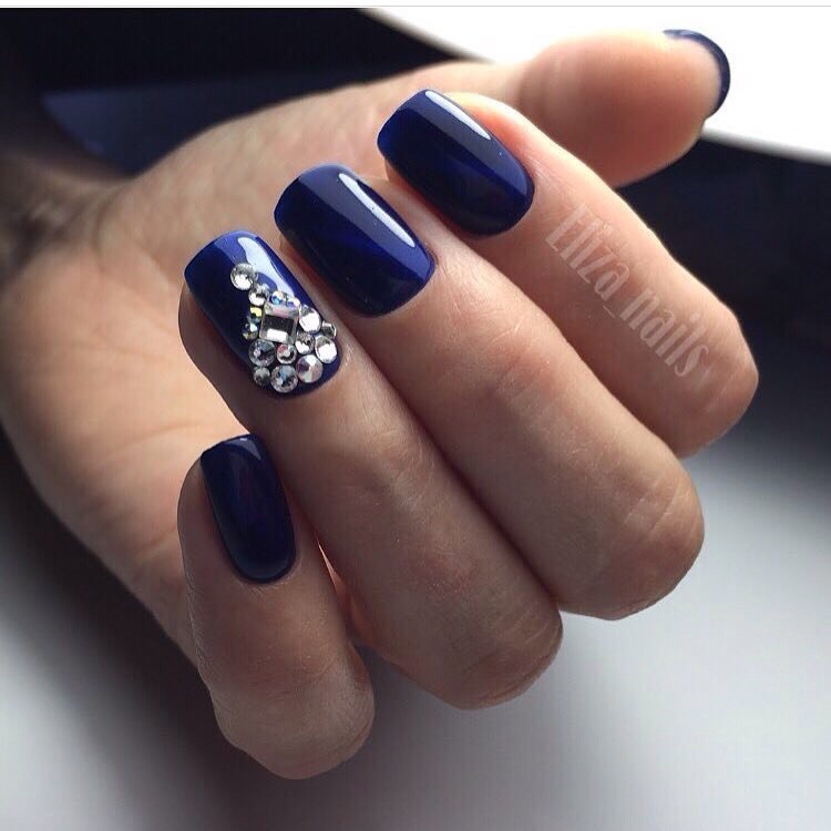 Максималістичний синій манікюр з блискучими стразами на овальних нігтях