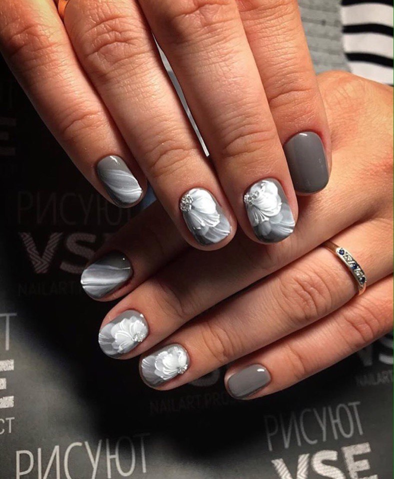 Сіро-білий манікюр: овальна елегантність з квітковим розписом та сяйвом стразів