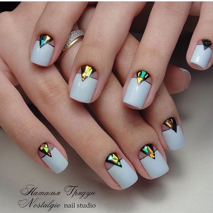 Сірий манікюр з золотими геометричними елементами і негативним простором