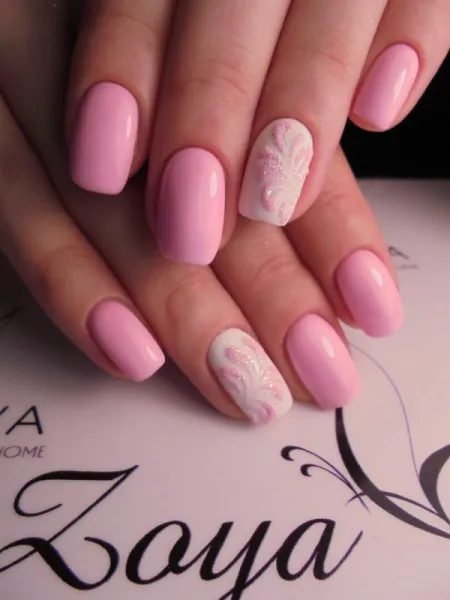 Ніжний рожевий з білим квітковим розписом та блискітками на овальних нігтях