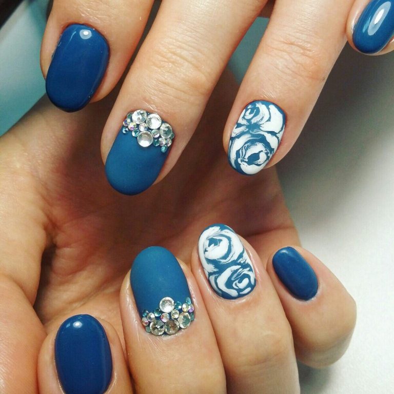 Розкішний синій матовий манікюр: 3D квіти, срібні акценти та стрази на овальних нігтях