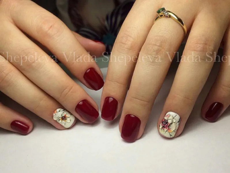 Бордові нігті з білим квітковим розписом: овальні, блискучі, короткі