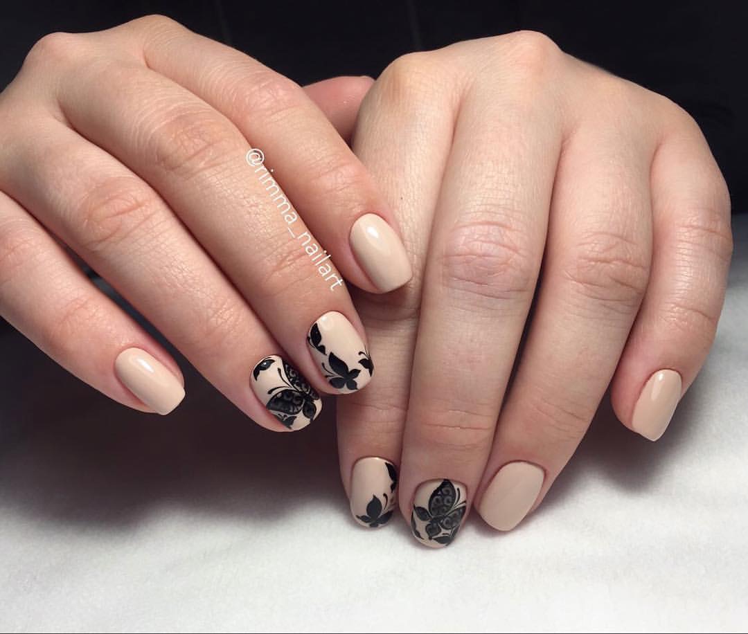 Бежевий манікюр з чорним квітковим ручним розписом на овальних нігтях