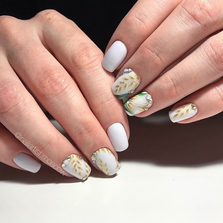 Білий матовий манікюр з об'ємними золотими квітами та стразами