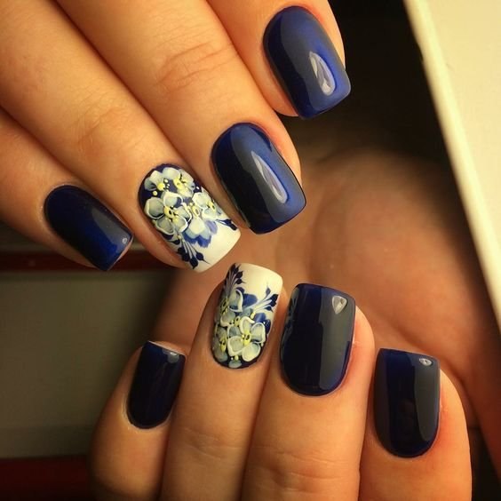 Синій манікюр з квітковим ручним розписом на овальних нігтях