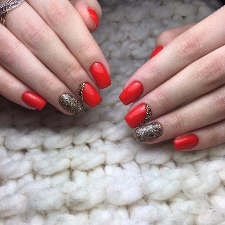 Святковий червоно-золотий манікюр: овальні нігті з блискітками та стразами
