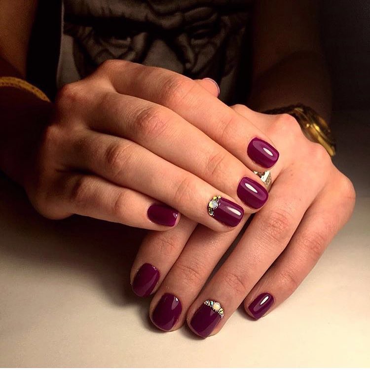 Бордовий манікюр з золотим блиском та стразами на овальних нігтях