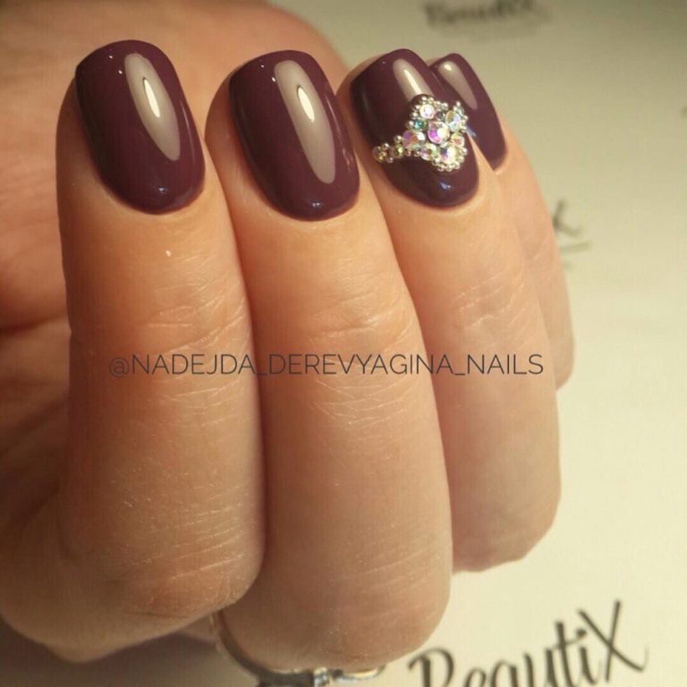 Бордовий манікюр з блискітками та стразами на овальних нігтях