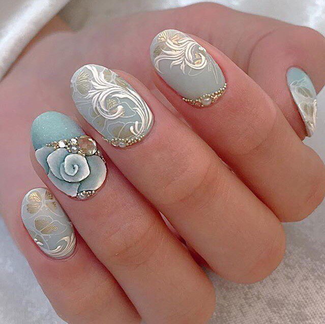 Зелений 3D манікюр із золотими квітами та стразами на овальних нігтях