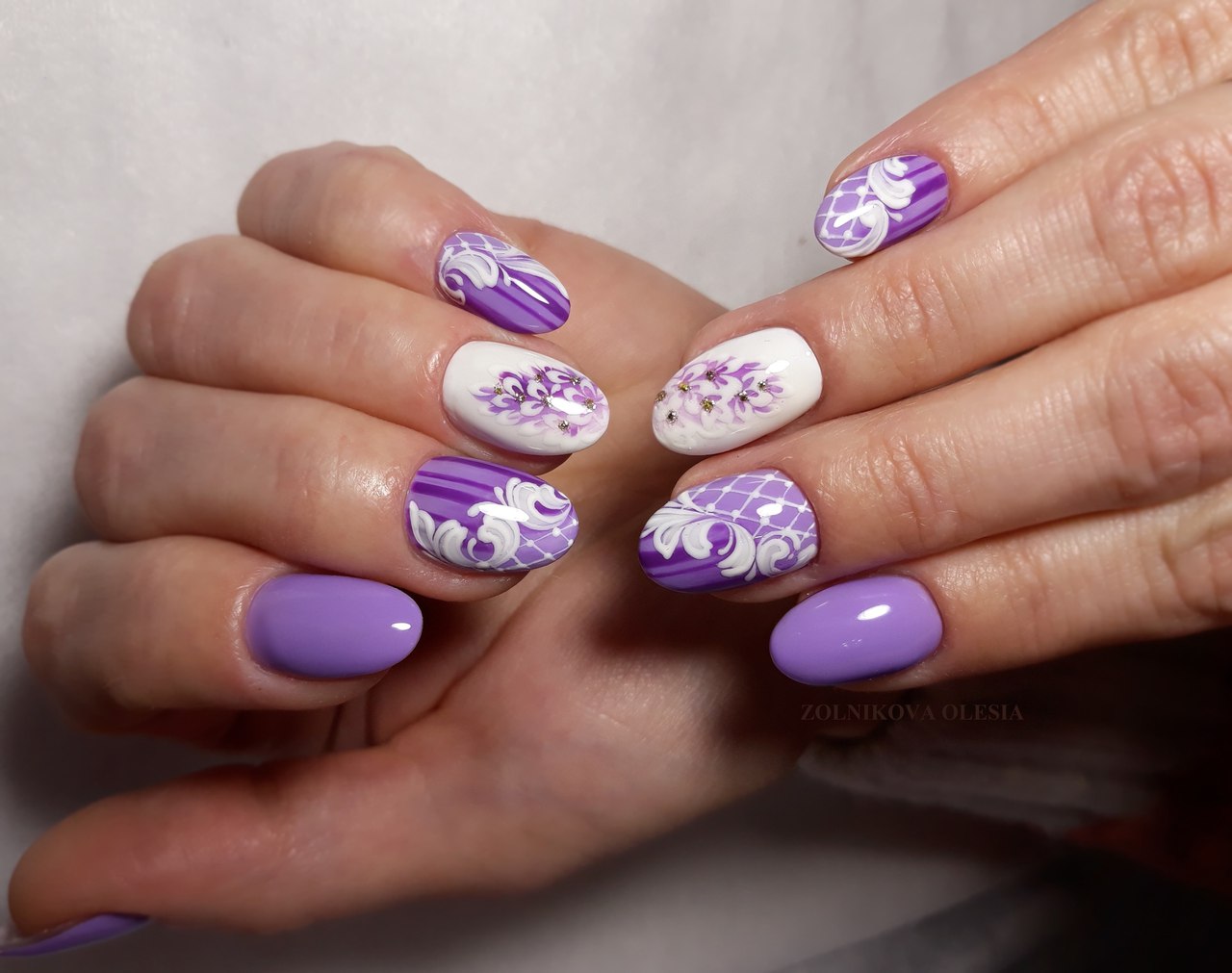 Фіолетовий манікюр з абстрактними квітами та срібними стразами