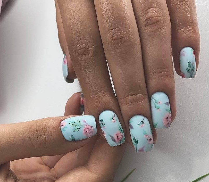 Матовий синій манікюр з квітковими візерунками на овальних нігтях