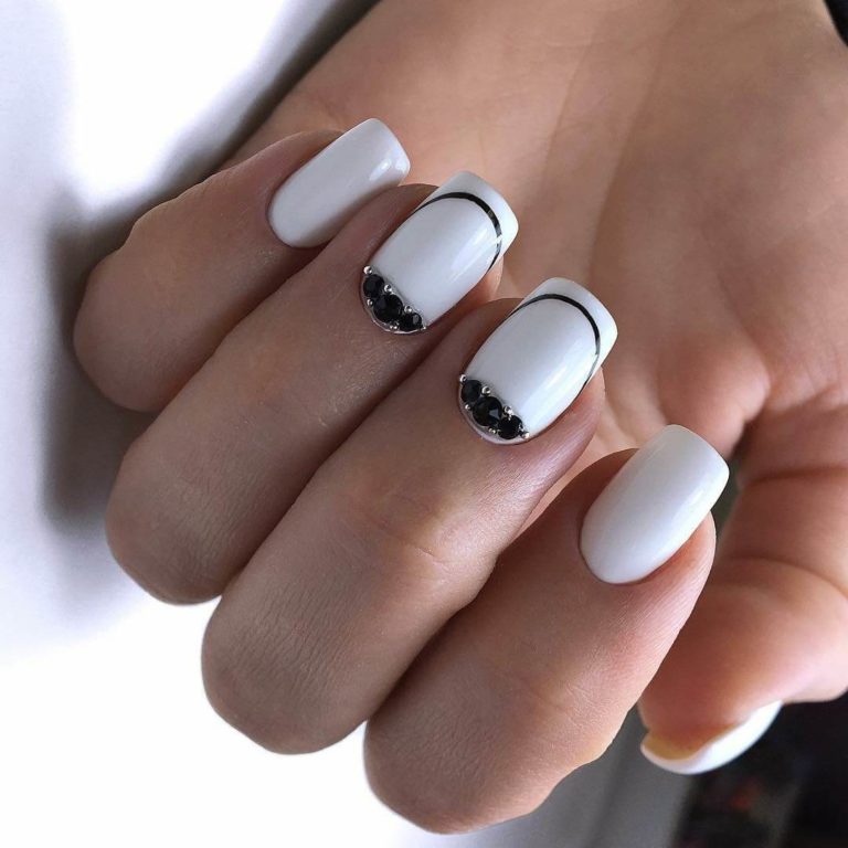 Білий манікюр з чорною геометрією та стразами на овальних нігтях
