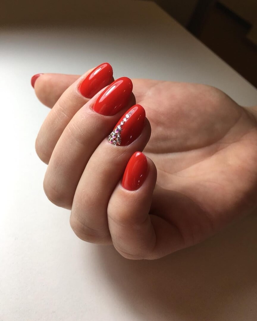 Червоний манікюр із сріблястими стразами на мигдалеподібних нігтях
