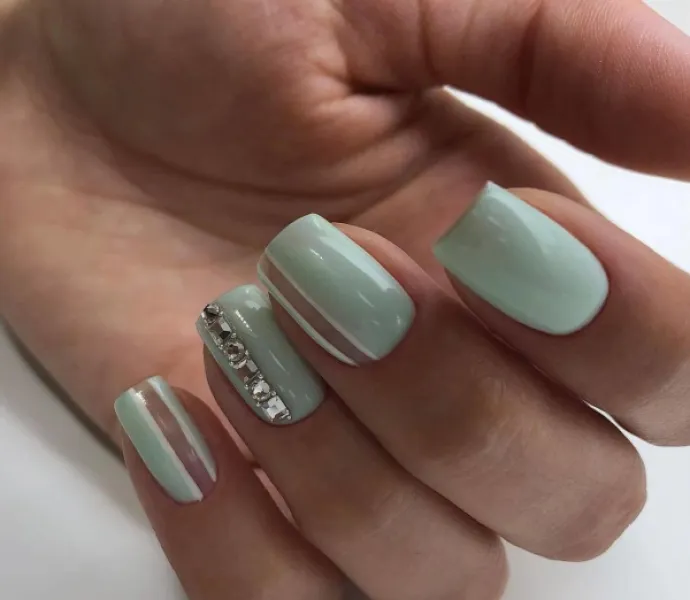 Квадратний зелений манікюр з білими і сріблястими геометричними елементами