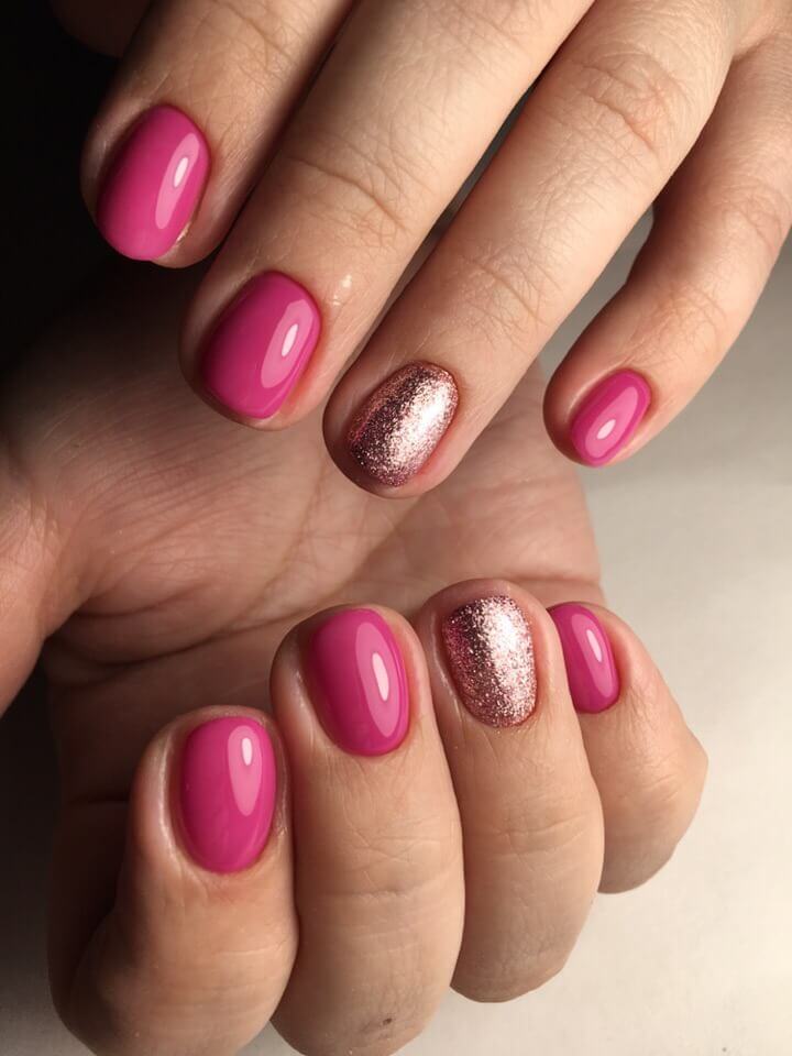 Рожевий блискучий гель-лак: короткі круглі нігті із золотими іскорками