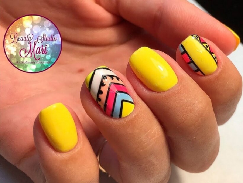 Жовтий геометричний манікюр з яскравим ручним розписом на коротких нігтях