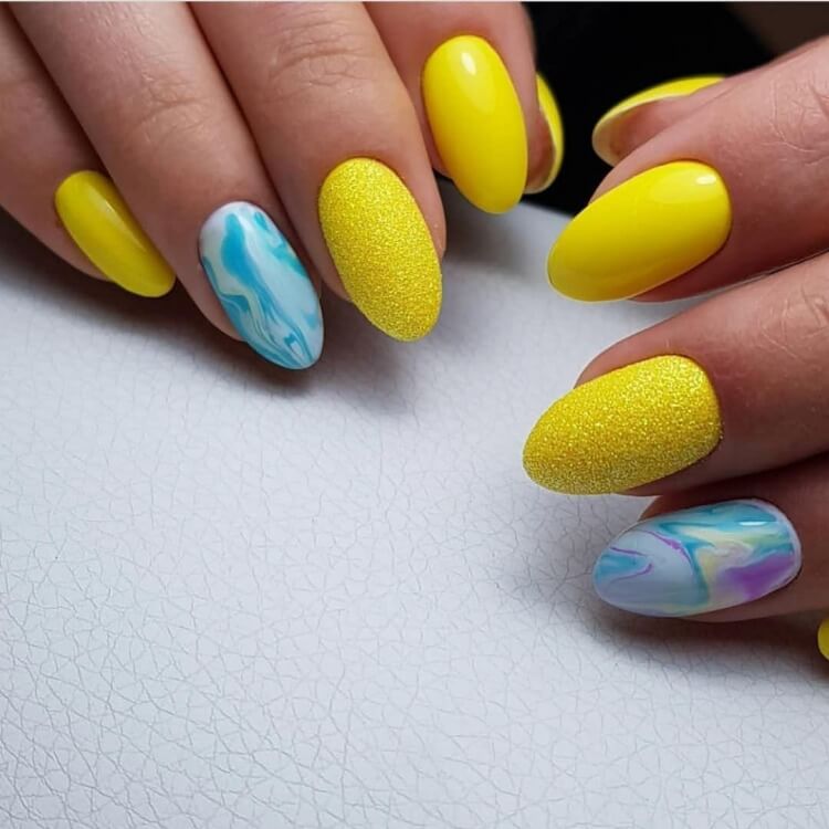 Абстрактний манікюр: жовті та сині відтінки на мигдалеподібних нігтях