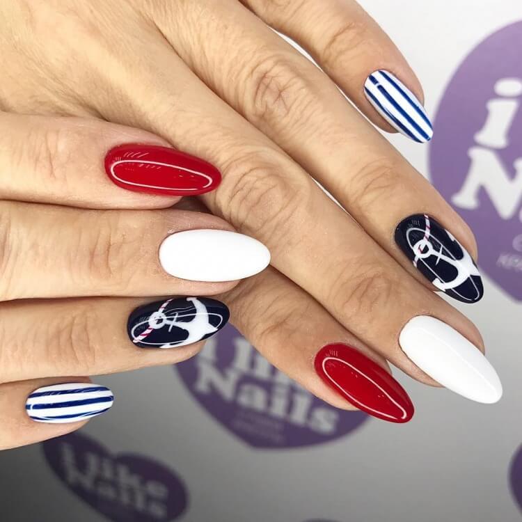Червоний манікюр з синіми геометричними лініями на мигдалевих нігтях