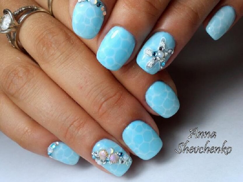 Синій манікюр з 3D елементами та сріблястими стразами на овальних нігтях