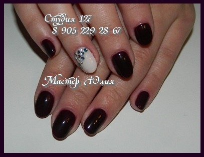 Бордовий манікюр з білими та сріблястими стразами на овальних нігтях