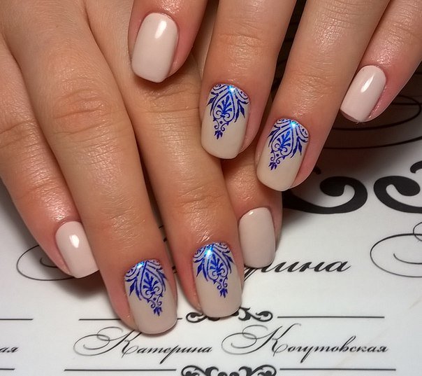 Бежевий манікюр з синіми абстрактними візерунками на овальних нігтях