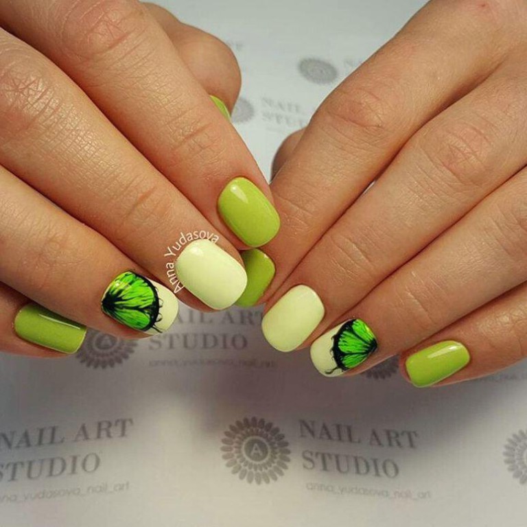Зелений манікюр з ручним розписом жовтих квітів на коротких круглих нігтях