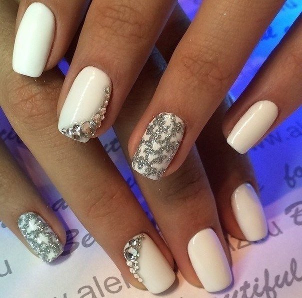 Білий манікюр з блискітками та срібними стразами на овальних нігтях