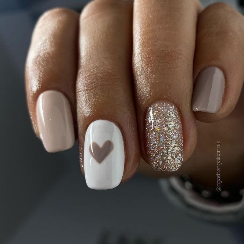 Елегантний бежевий манікюр: овальні нігті з білим мінімалістичним розписом та блиском